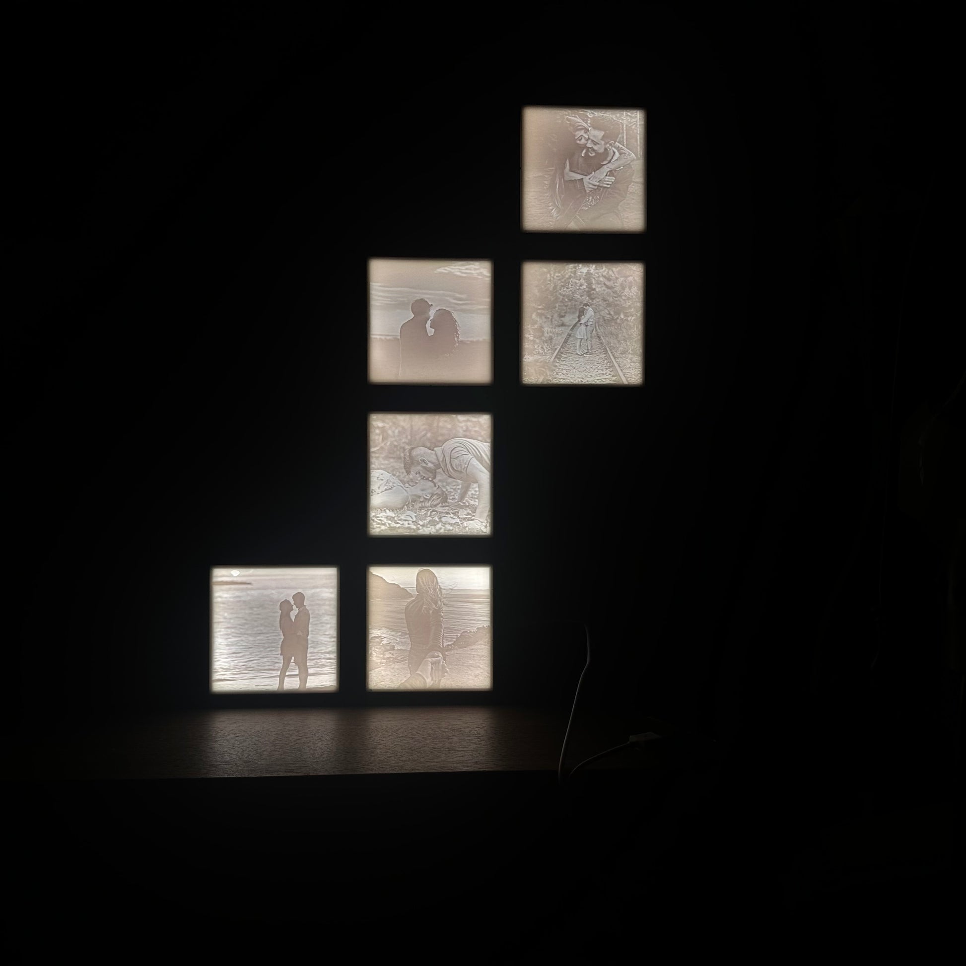 Zes verlichte fotoframes met 3D-geprinte lithofane foto's van verliefde koppels, gestapeld tot één geheel – sfeervolle, warme presentatie als unieke wanddecoratie.